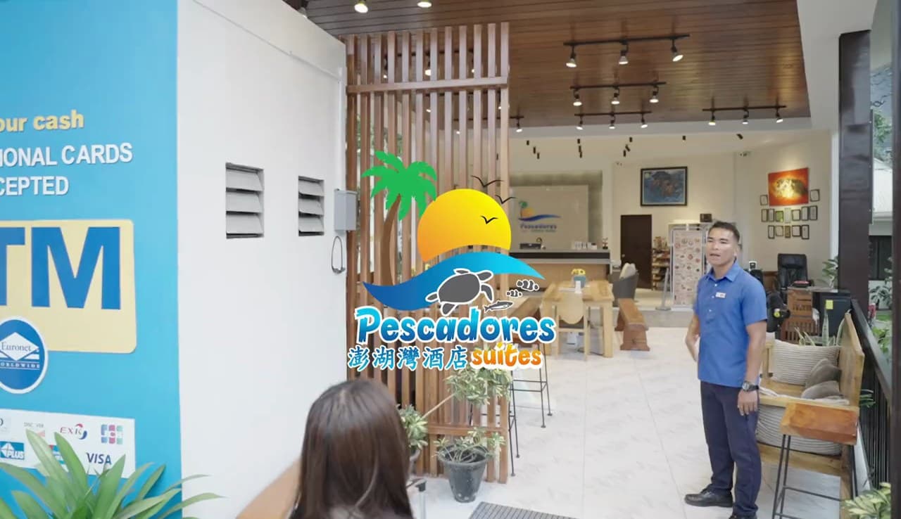 A Pescadores Suites staff member greeting a guest in the lobby